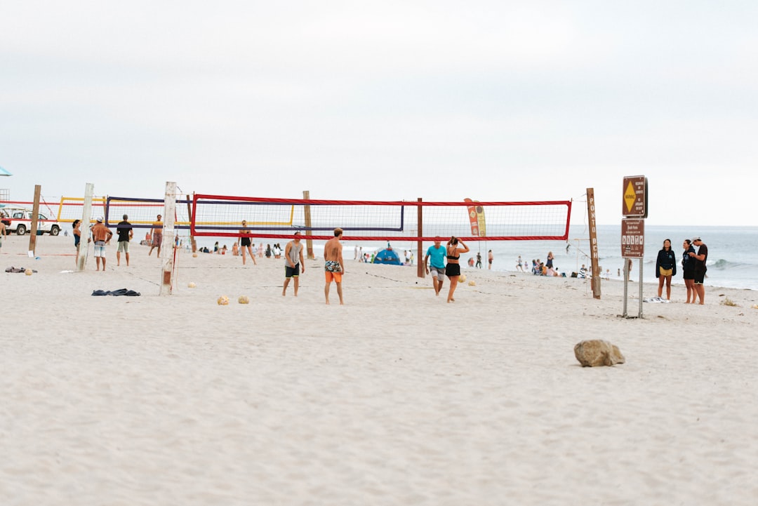 people playing beach volleyball on beach during daytime