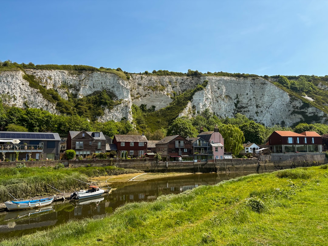 Charming village with white cliffs, a river, and green banks.