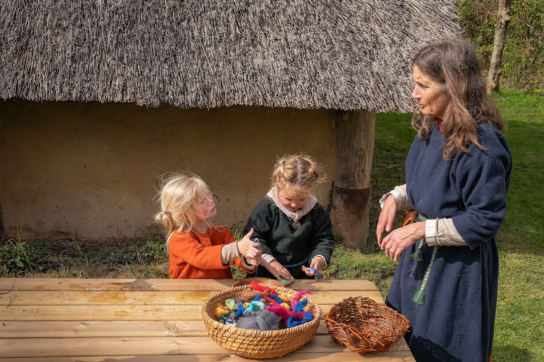 Woman teaching children historical crafts outdoors