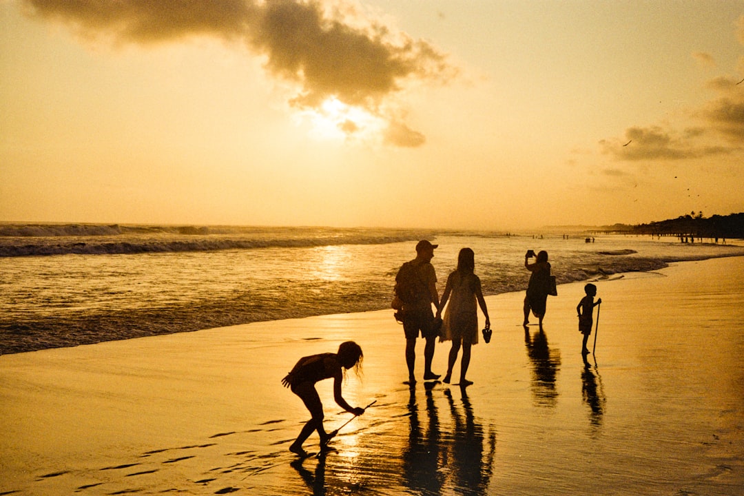 Family walking on beach at sunset