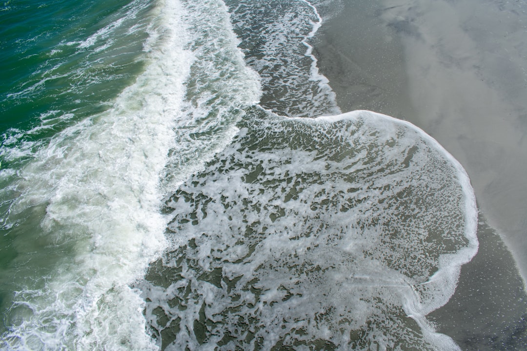 Ocean waves crash onto the sandy shore.