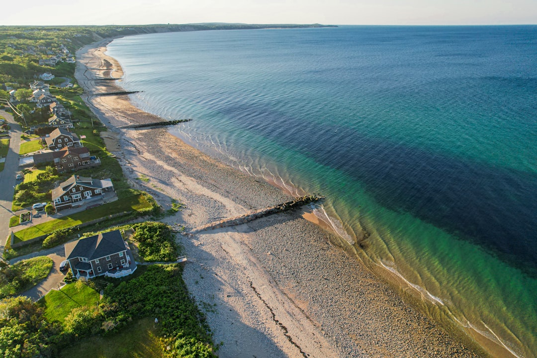 Aerial view of the Cape Cod coastline with beach cottages and turquoise water near Chatham