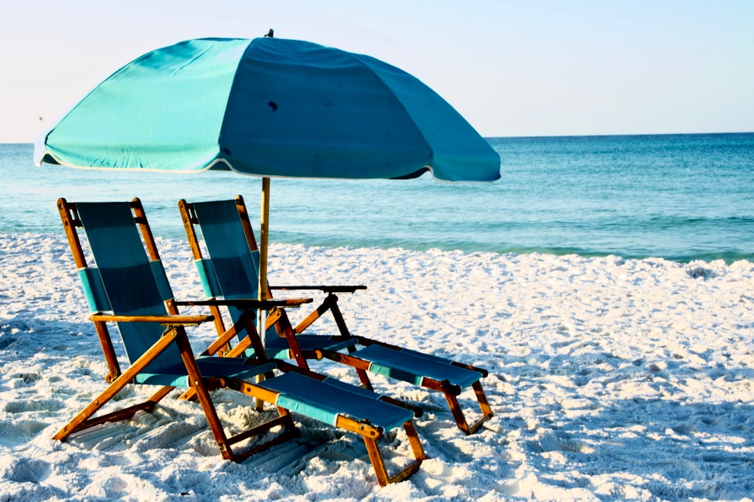 Beach chairs and a striped umbrella facing the Gulf at Destin, Florida