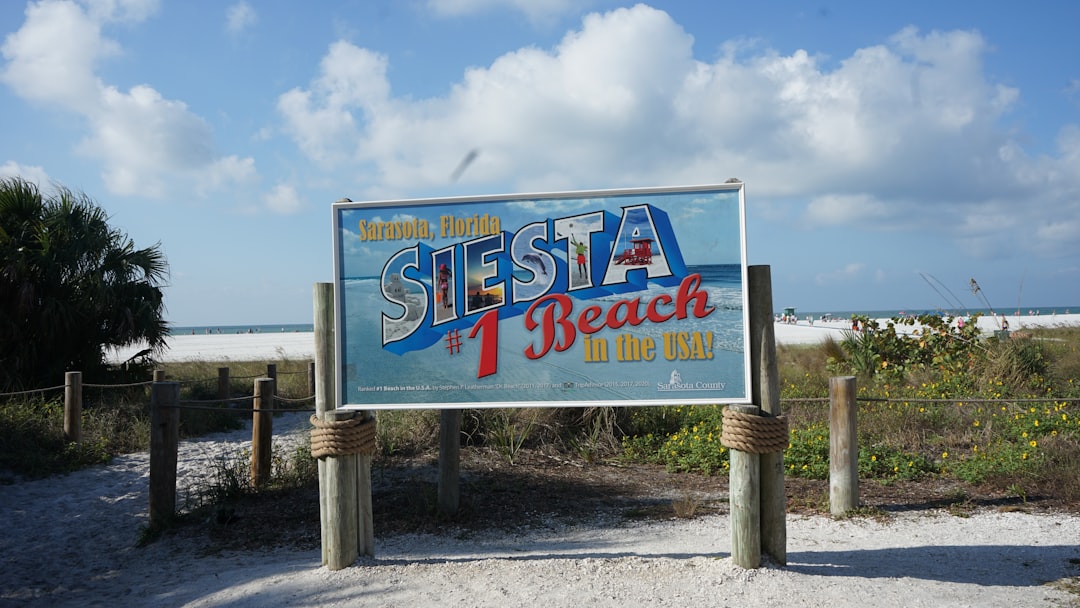The Siesta Beach sign on the dunes at Siesta Key, Florida