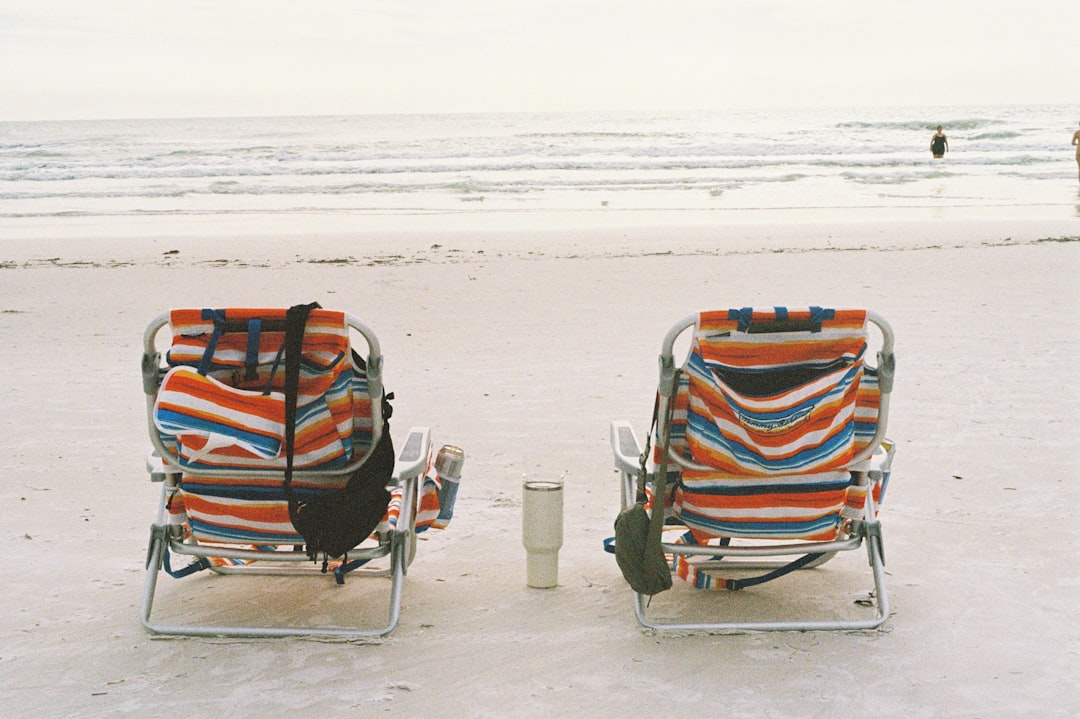 Two colorful beach chairs on the white quartz sand of Siesta Key