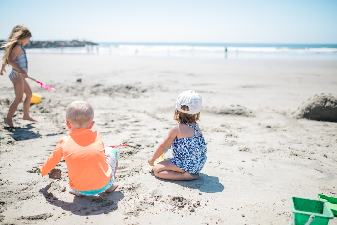 Toddlers playing in the sand on a wide flat white sand beach