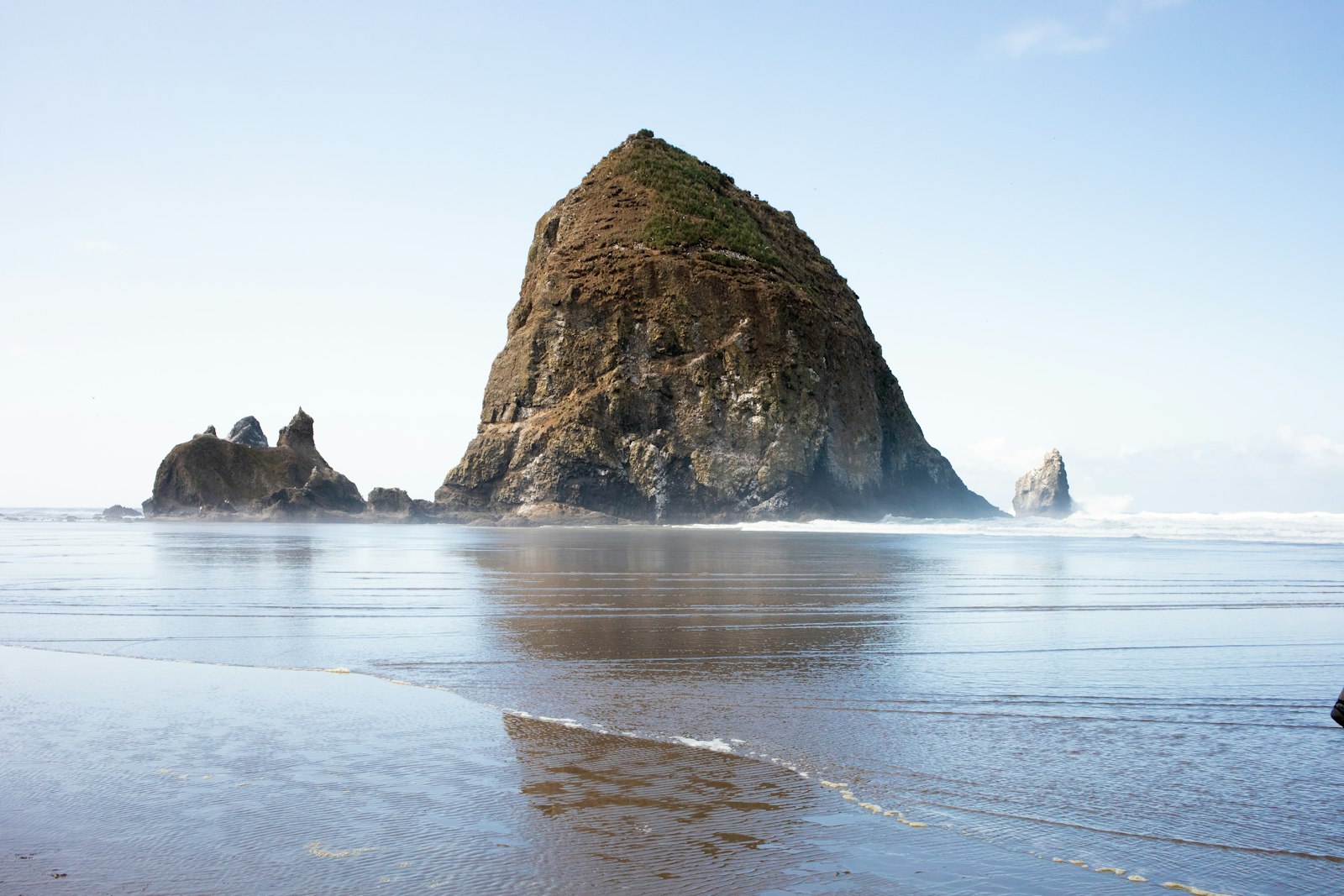 Haystack Rock rising from the sand at low tide at Cannon Beach, Oregon