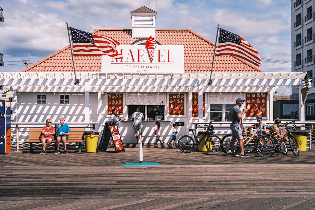 An ice cream shop and US flags on a wooden beach boardwalk