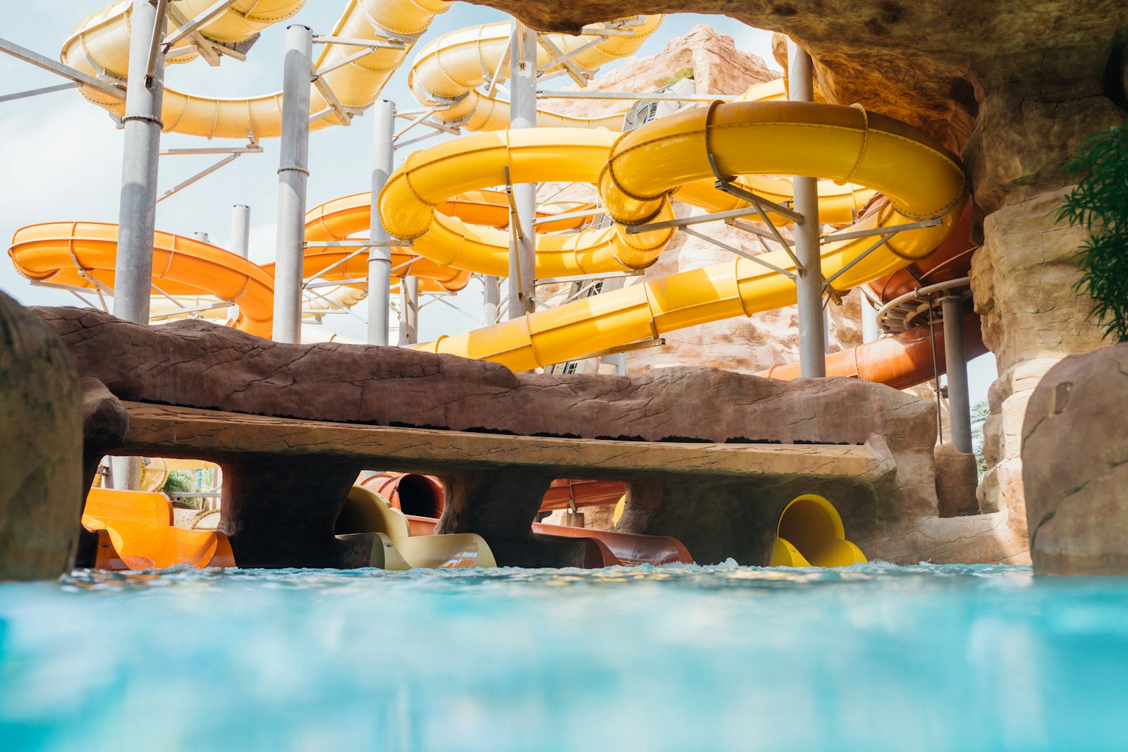 Yellow water slides above a clear blue waterpark pool