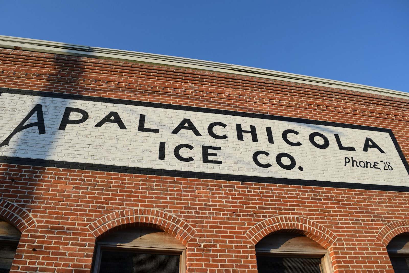 The painted brick facade of the Apalachicola Ice Co building in Apalachicola, Florida