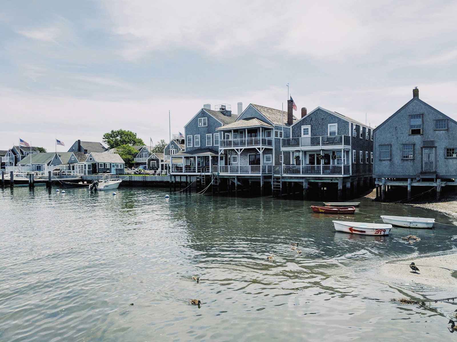 Grey-shingled houses and small boats along a harbour on Cape Cod, Massachusetts